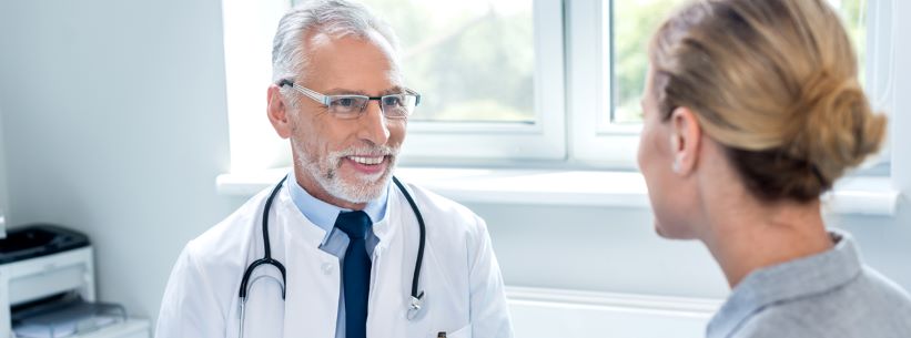 doctor in his office smiling at patient